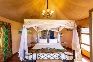 ein Schlafzimmer mit einem Himmelbett in der Unterkunft Ikoma Wild Camp in Robanda