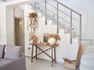 ein Wohnzimmer mit einem Tisch und einer Treppe in der Unterkunft Luxury Getaway in Zante-Eliá Luxury Villas in Akrotiri