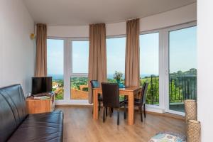 een woonkamer met een tafel en stoelen en grote ramen bij Villa Entre in Emona