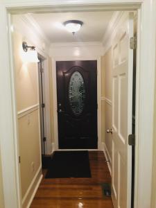 un pasillo con una puerta negra y una alfombra negra en MooreField Suites Greensboro East, en McLeansville