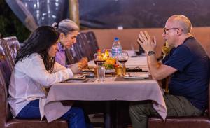 un grupo de personas sentadas en una mesa en Ikoma Wild Camp, en Robanda