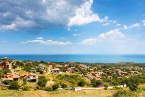 un village sur une colline avec l'océan en arrière-plan dans l'établissement Villa Entre, à Emona