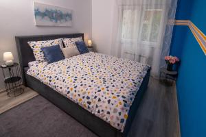 Schlafzimmer mit einem Bett mit Polka-Punkten-Bettwäsche in der Unterkunft Apartman Point in Pula