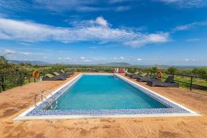 a swimming pool with lounge chairs and a view at Serengeti Safari Lodge in Banagi