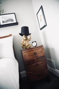 um urso de peluche sentado numa cómoda com uma cartola em A Stylish 2 Bed Apartment in Cobh Town - Lux Stay em Cobh