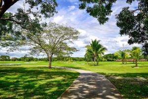 a path through a golf course with palm trees at Laguna Lake House - Private Pool - Sleeps 12 - Elegant in Playa Blanca