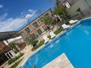 a large blue swimming pool in front of a building at SiriuS Otel Pamukkale in Pamukkale
