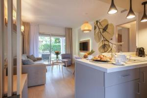 cocina y sala de estar con sofá y mesa en Brise Marine piscine St Tropez II, en Saint-Tropez