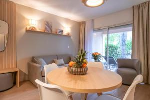 sala de estar con mesa de comedor y sofá en Brise Marine piscine St Tropez II, en Saint-Tropez