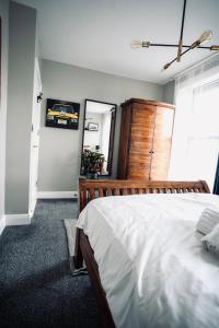 1 dormitorio con 1 cama grande y vestidor de madera en A Stylish 2 Bed Apartment in Cobh Town - Lux Stay, en Cobh