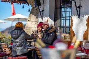 a man and woman sitting at a table in a restaurant at Le Coucou Hotel Restaurant & Lounge-Bar in Montreux