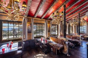 a restaurant with tables and chairs and windows at Le Coucou Hotel Restaurant & Lounge-Bar in Montreux