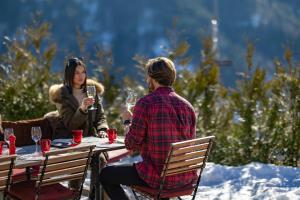 a man and woman sitting at a table with wine glasses at Le Coucou Hotel Restaurant & Lounge-Bar in Montreux