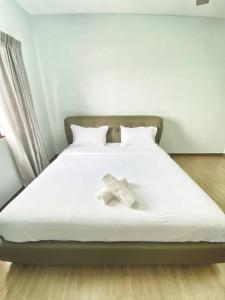 a bed with a white sheet and a book on it at Spacious 3 rooms Apartment@Desa Putra Condominium in Kuala Lumpur