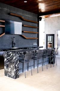 - un bar dans une pièce dotée de murs noirs et de chaises dans l'établissement Villa Sophia Valle de Guadalupe, à Valle de Guadalupe