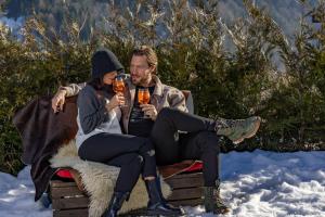a man and a woman drinking wine in the snow at Le Coucou Hotel Restaurant & Lounge-Bar in Montreux