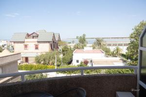 d'un balcon avec vue sur l'eau et les bâtiments. dans l'établissement Balcón a Doñana, à Sanlúcar de Barrameda