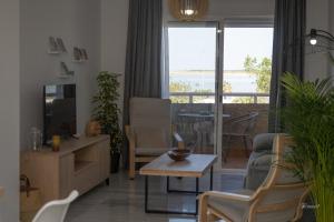 sala de estar con sofá, TV y mesa en Balcón a Doñana, en Sanlúcar de Barrameda