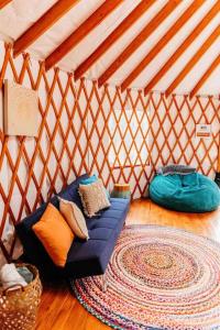 a room with a blue couch in a yurt at Heated & AC Yurt in Penn Yan