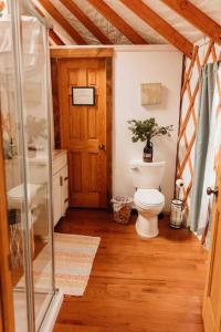 baño con aseo y puerta de cristal en Heated & AC Yurt, en Penn Yan