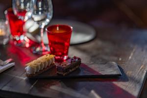 a table with two pieces of dessert and a red glass at Le Coucou Hotel Restaurant & Lounge-Bar in Montreux