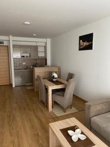 a living room with a dining room table and a kitchen at Gondola Mako Exclusive in Zlatibor