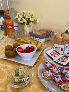 une table recouverte de assiettes de nourriture et de fruits dans l'établissement B&B Palazzo Pancaro, à Altomonte