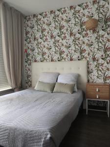 sypialnia z łóżkiem i tapetą w kwiaty w obiekcie Studio cabine Marché de Noël - Vue mer w mieście Le Barcarès