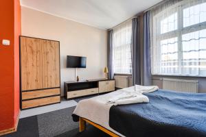 a bedroom with a bed and a flat screen tv at Hotel Sowa in Elblag