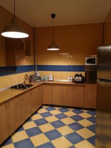 a kitchen with wooden cabinets and a checkered floor at Casa Miu in Sinaia