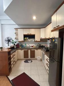 a kitchen with white cabinets and a stainless steel refrigerator at Riverbank suites 1008 in Kuching