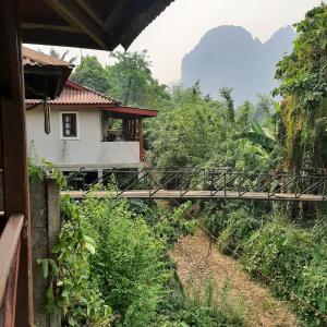a house with a bridge over a field of trees at Maylyn Guesthouse in Vang Vieng