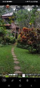 un chemin en pierre dans un jardin avec une maison dans l'établissement Maylyn Guesthouse, à Vang Vieng