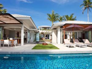 a villa with a swimming pool and a house at Inasia Beach Villa by Elite Havens in Lipa Noi
