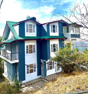 a blue house on top of a hill at Hill Side Inn in Shimla