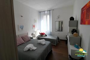 sypialnia z dwoma łóżkami i ręcznikami na nich w obiekcie Maremma Holidays -Trento Apartment w mieście Follonica