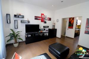 salon z płaskim telewizorem na ścianie w obiekcie Maremma Holidays -Trento Apartment w mieście Follonica