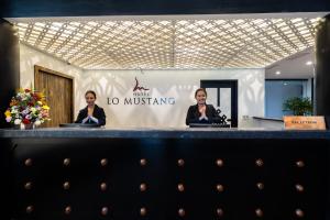 two people sitting at a counter in a lobby at Hotel Lo Mustang in Kathmandu
