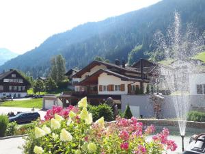 a house with a fountain in a garden with flowers at Haus Dagmar in Silbertal