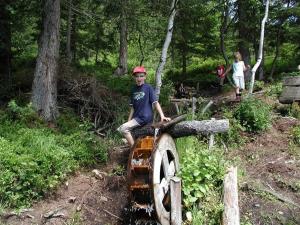 a young boy sitting on top of a wooden wheel at Haus Dagmar in Silbertal