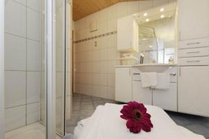 a bathroom with a bed with a red flower on it at Haus Dagmar in Silbertal