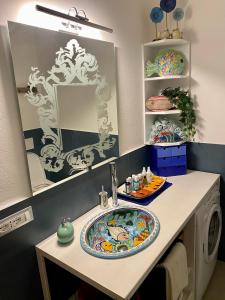 a bathroom with a sink and a washing machine at Appartamento appena ristrutturato completo di tutti i comfort a un passo dal centro in Tortolì