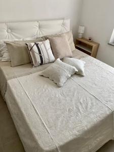 a white bed with two pillows on top of it at Appartamento appena ristrutturato completo di tutti i comfort a un passo dal centro in Tortolì