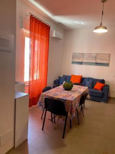 a living room with a table and a blue couch at Appartamento appena ristrutturato completo di tutti i comfort a un passo dal centro in Tortolì