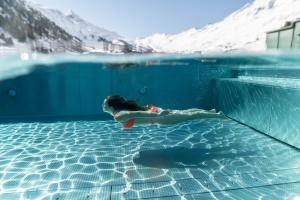 Ein junges Mädchen, das im Schwimmbad schwimmt. in der Unterkunft Hotel Enzian & Apartmenthotel Johannes in Obergurgl