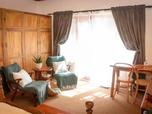 a living room with chairs and a large window at Place of Sonlight in Swellendam