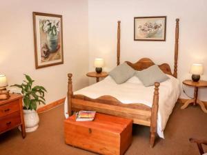 a bedroom with a large bed with a wooden frame at Place of Sonlight in Swellendam