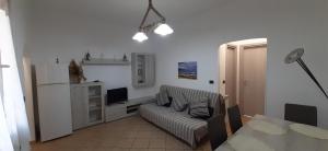 a living room with a couch and a television at CASA PRIMAVERA in Vado Ligure