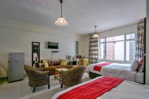 a hotel room with two beds and a living room at Marlborough apartment 509 in Durban
