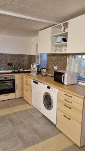 a kitchen with a washing machine and a microwave at Modern eingerichtete 3-Zi-Ferienwohnung zu vermieten in Löffingen